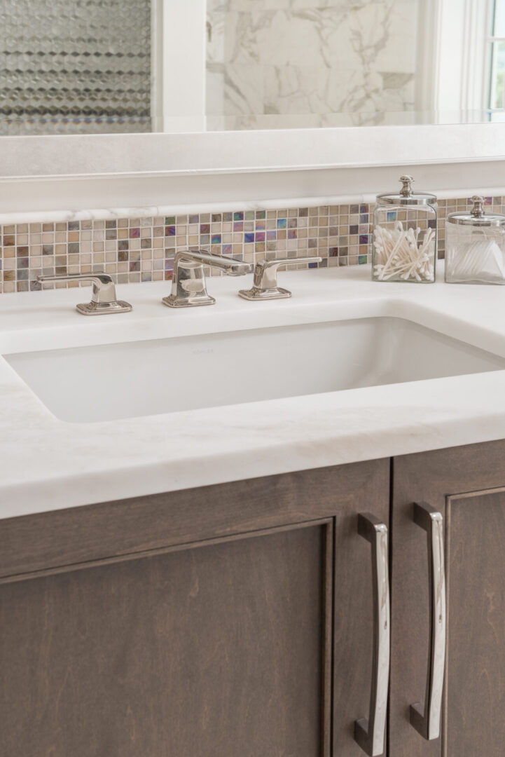 A Whites Color Sink With Steel Fittings and Mirror
