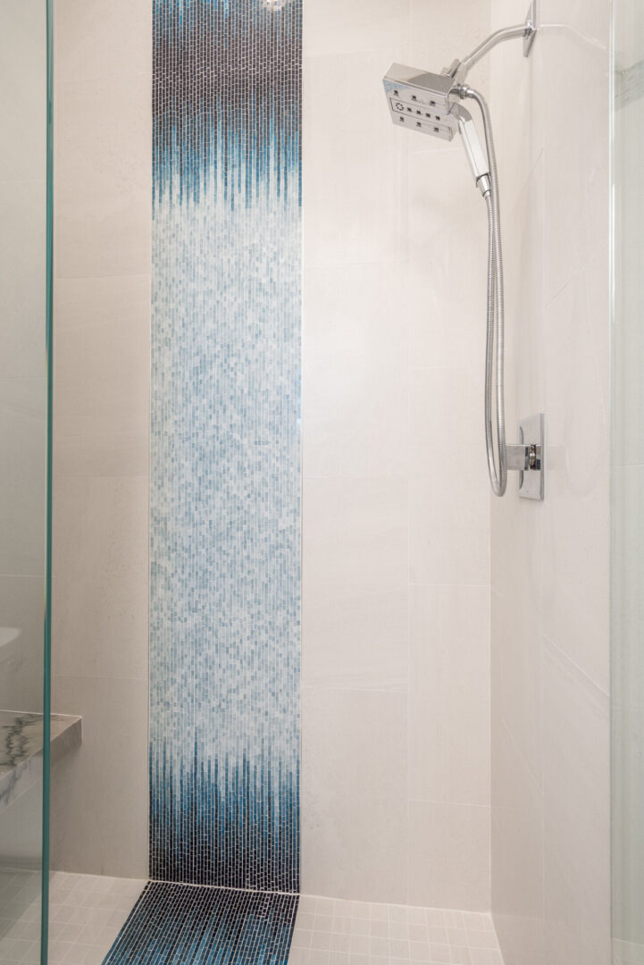 A Tiled Shower Space With Glass Doors and Bench