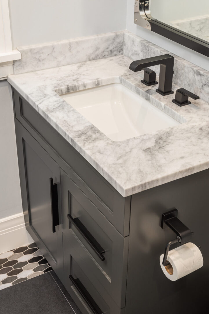 A Marble Counter for White Sink With Black Fittings