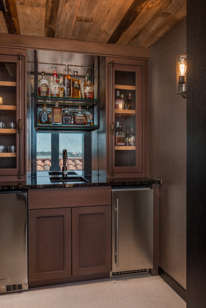 A Bar Cabinet With Fridge and Sink With Mirror