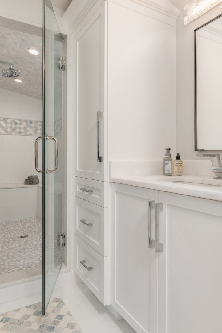 A Shower Unit With Glass Door and White Cabinets