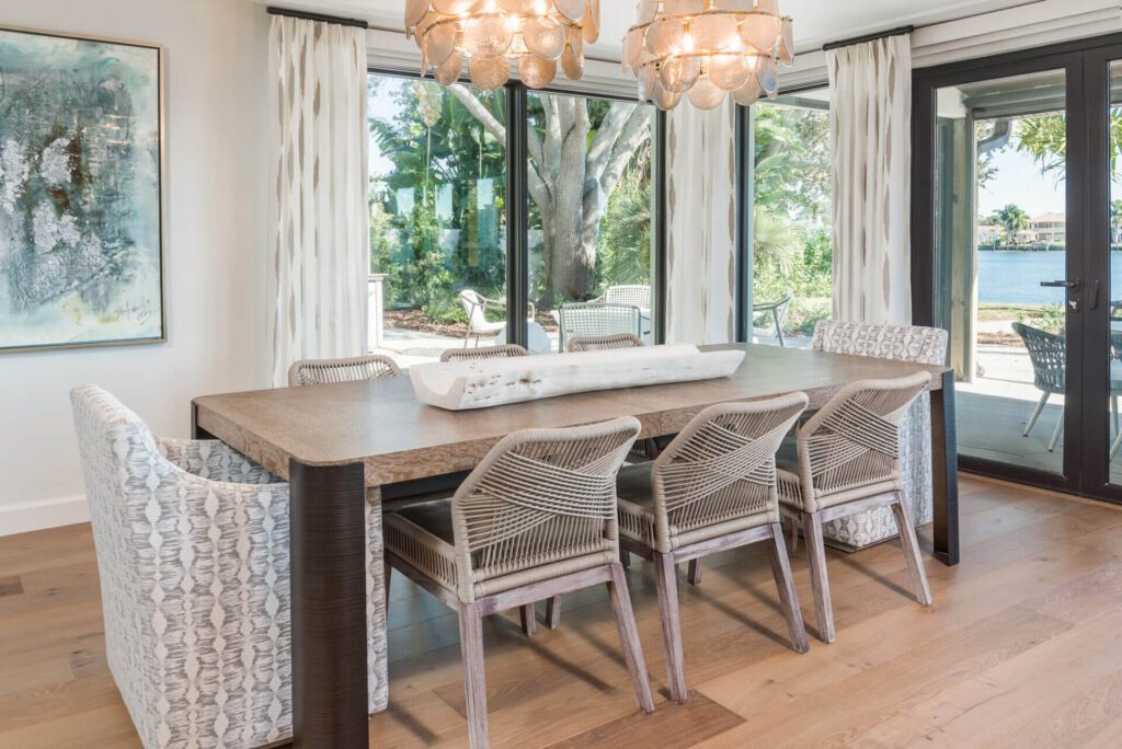 A dining room table with four chairs and two lamps.