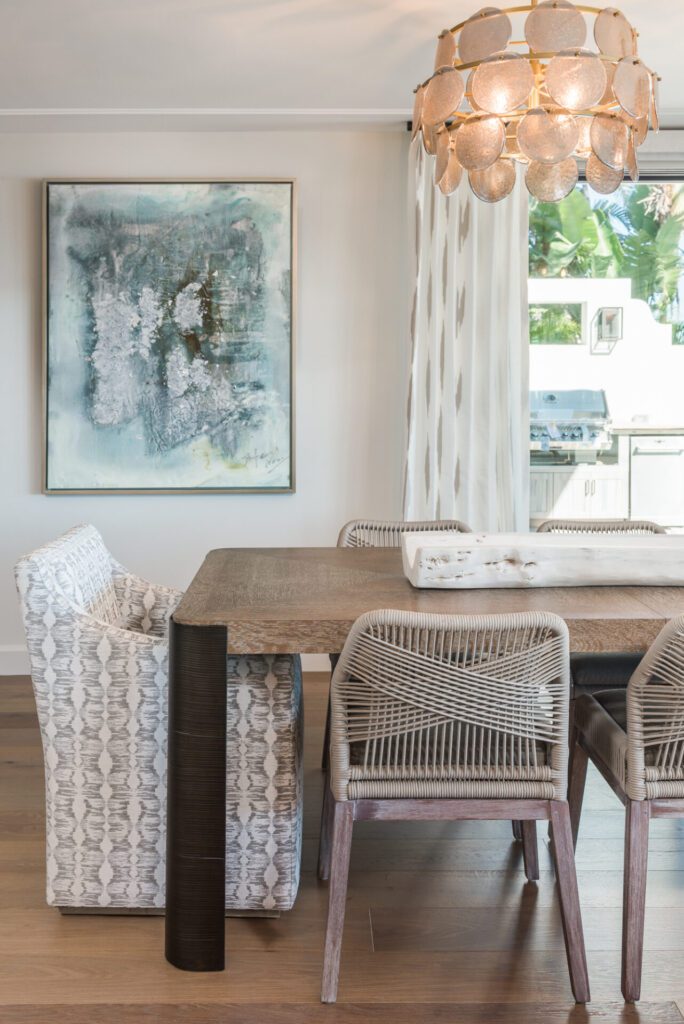 A dining room table with chairs and a painting on the wall.