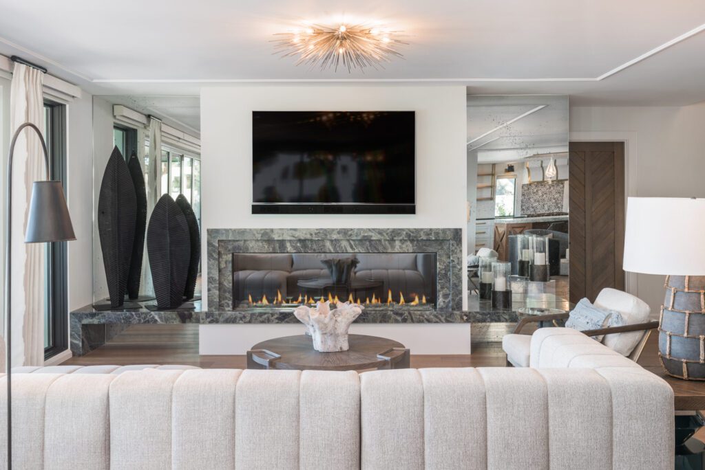 A living room with a couch, fireplace and television.