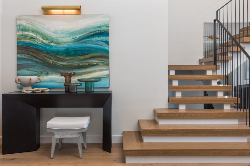 A room with stairs and a painting on the wall