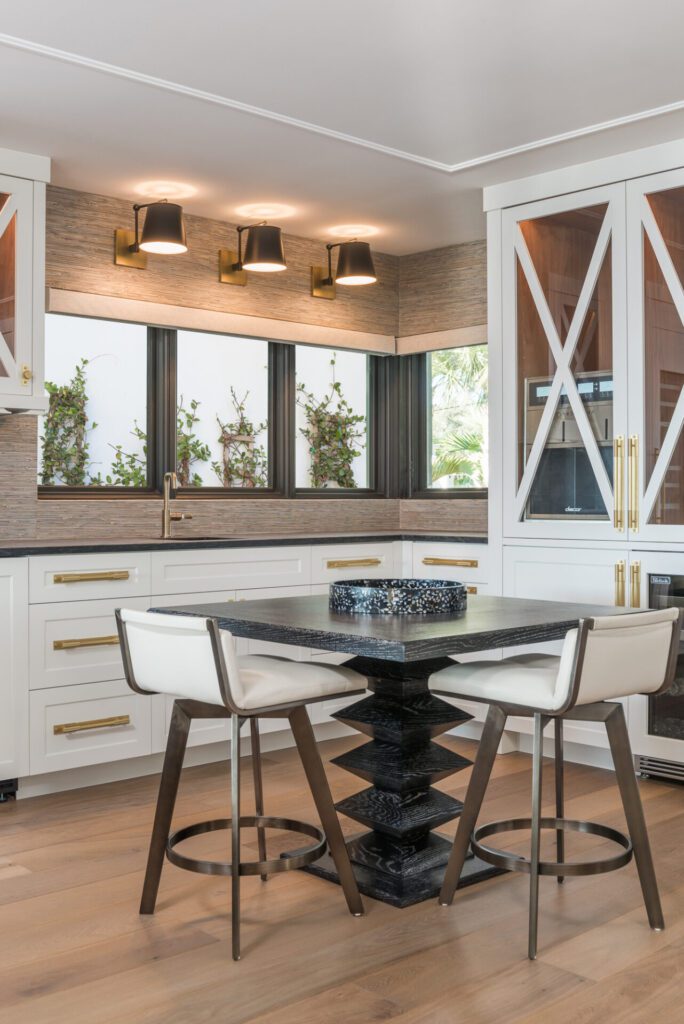 A kitchen with white cabinets and black table