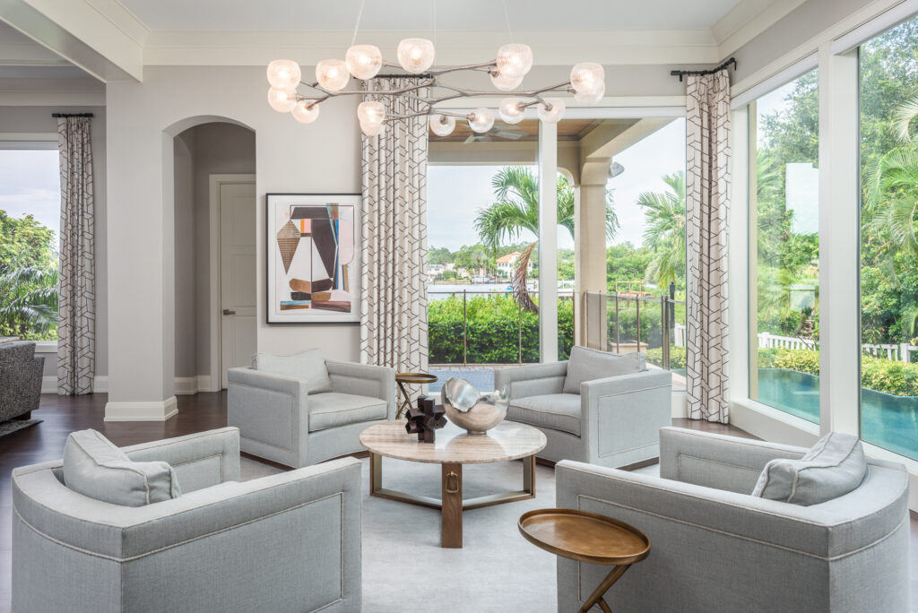 A living room filled with furniture and large windows.