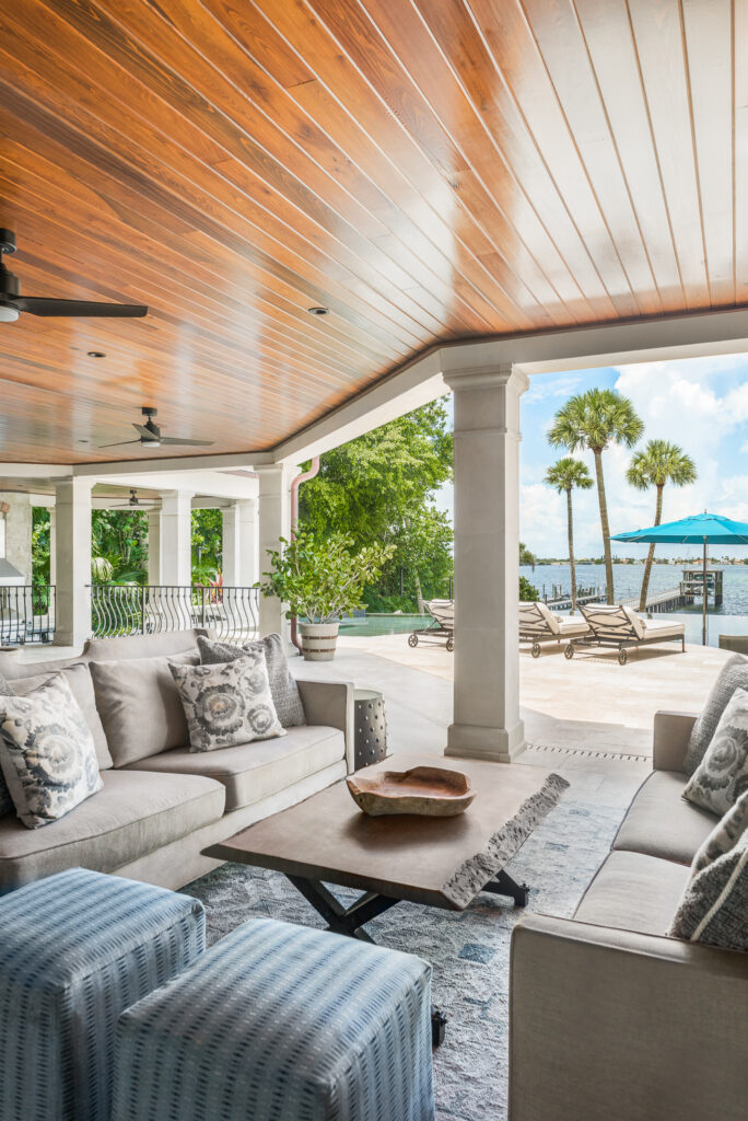 A large covered patio with furniture and a table.