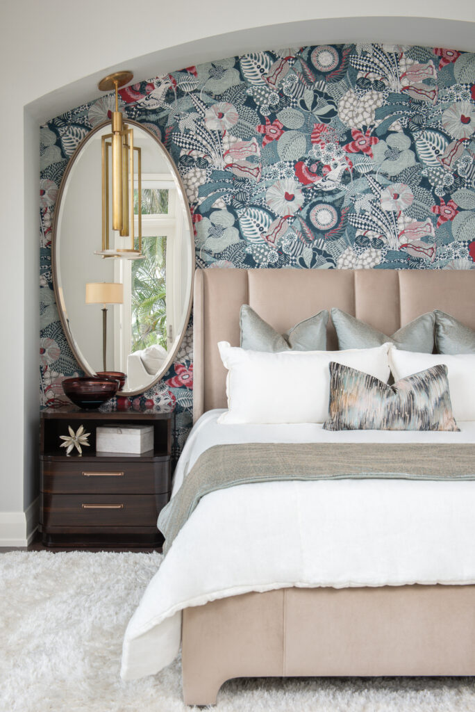 A bedroom with floral wallpaper and a bed