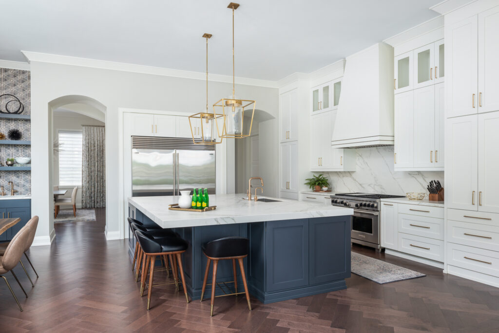 A kitchen with white cabinets and black island.